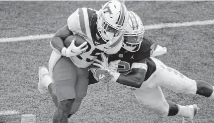  ?? GERRY BROOME/ASSOCIATED PRESS ?? Virginia Tech running back Khalil Herbert scores a touchdown as North Carolina defensive back Don Chapman tries to tackle him during the first half Saturday at Kenan Stadium. Herbert, one of the nation’s top rushers so far this year, ran 18 times for 138 yards and two touchdowns in the loss.