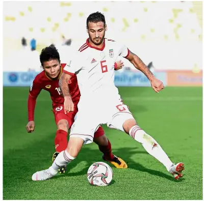  ?? — AFP ?? Going all out: Vietnam midfielder Quang Hai Nguyen (left) in action against Iran midfielder Ahmad Nourollahi during the Asian Cup Group D match at the Al-Nahyan Stadium in Abu Dhabi on Saturday.