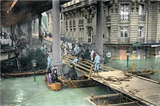  ??  ?? En janvier 1910, la Seine a connu une crue terrible, mettant Paris sous une hauteur jamais atteinte depuis. En photo : constructi­on d’un pont provisoire dans le quartier de Passy.