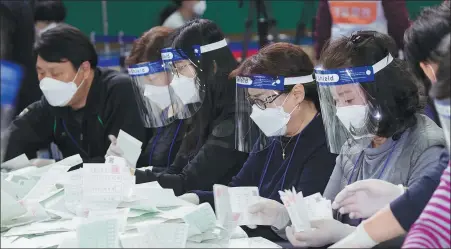  ?? LEE SANG-HO / XINHUA ?? Ballots are counted at a polling station for the parliament­ary elections in Seoul, South Korea, on Wednesday.