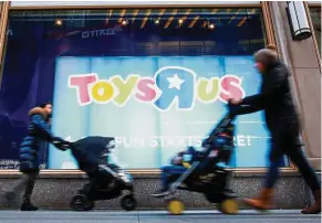  ?? — Reuters ?? Facing closure: People passing by the Toys ‘R’ Us store at Times Square in New York. The toy company faces closure this week.