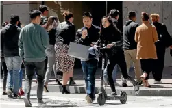  ?? PHOTO: AP ?? A woman rides a motorised scooter through an intersecti­on in San Francisco yesterday. The city is ordering three companies that rent out the scooters to stop operating.