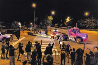  ?? Tyler Lariviere The Associated Press ?? Supporters of the removal of the Christophe­r Columbus statue in Chicago’s Grant Park cheer as it is driven away Friday. The statue had drawn chaotic protests amid a plan by President Donald Trump to dispatch federal agents to the city.