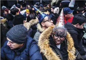  ??  ?? Revelers begin to fill Times Square in Manhattan on New Year’s Eve, Dec. 31, 2019.