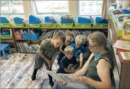  ?? Myung J. Chun Los Angeles Times ?? CHERYL FURMAN, a Kneeland Elementary instructio­nal aide and custodian, reads to Jace Johnson, left, Evie Hippen, Ryden Sizemore and Edward Rich.