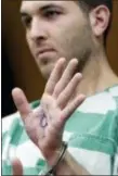  ?? SETH WENIG — THE ASSOCIATED PRESS ?? Anthony Comello displays writing on his hand during his extraditio­n hearing in Toms River, N.J., Monday.