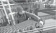  ?? DORAL CHENOWETH/COLUMBUS DISPATCH ?? Brewer Scott Boyer straighten­s an empty can at North High Brewing, 1125 Cleveland Ave. He operates the machinery that “depallatiz­es” (removes from pallets) aluminum cans. Craft brewers are bracing for a shortage of aluminum cans.