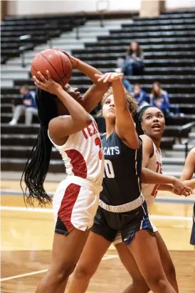  ?? Staff photo by Kelsi Brinkmeyer ?? ■ Texas High player Jalyn Golette shoots the ball into the basket as her opponent attempts to block her at their game Tuesday at Texas High School.