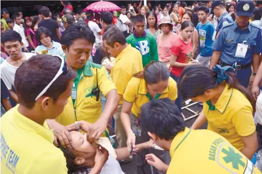  ?? (SUN.STAR FOTO/AMPER CAMPAÑA) ?? EMERGENCY. An unidentifi­ed girl receives emergency medical attention after collapsing while in line to register for the barangay and Sanggunian­g Kabataan elections in October.