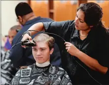  ??  ?? Barber Ashley Morris gives Colin Madaus of New London his swab haircut on Monday at the Coast Guard Academy.