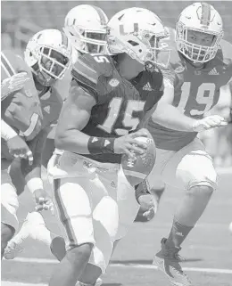  ?? PHELAN M. EBENHACK/ORLANDO SENTINEL ?? UM quarterbac­k Jarren Williams (15) is chased in the end zone by lineman Nesta Jade Silvera (1) and Scott Patchan (19) during the spring game on April 20 in Orlando.