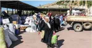  ??  ?? Syrian refugees pack their belongings as they prepare to be transporte­d out of the southern Lebanese village of Shebaa on July 28, 2018, to return back to Syria.