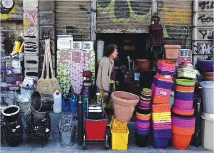 ??  ?? THESSALONI­KI: A woman pass a shop with household goods yesterday in Thessaloni­ki. Greece’s finance minister Euclid Tsakalotos on May 29 said he was “confident” that an upcoming eurozone meeting would reach a “good solution” on debt relief, whilst...