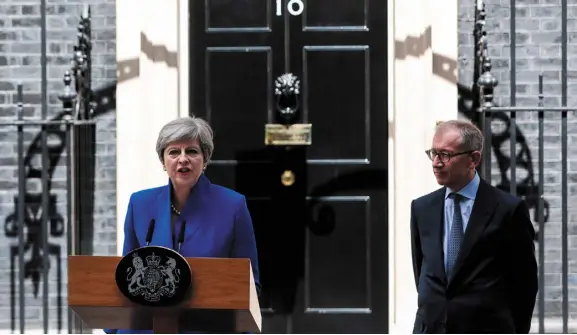  ??  ?? UK Prime Minister Theresa May delivers a speech as her husband, Philip May, watches outside number 10 Downing Street in London