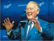  ??  ?? Retired broadcaste­r Vin Scully speaks to reporters about being inducted into the Los Angeles Dodgers Ring of Honor prior to the game between the Dodgers and the San Francisco Giants on Wednesday.