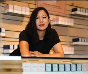  ?? AP PHOTO BY DAVID ZALUBOWSKI ?? In this Friday, July 26, 2019 photo, Leslie Siu poses for a portrait next to her cannabis products geared toward women, on display in Groundswel­l dispensary in east Denver. Pregnancy started out rough for her. Morning sickness and migraines had her reeling and barely able to function at a demanding New York marketing job, so like rising numbers of U.S. mothers-to-be, she turned to marijuana. “l was finally able to get out from under my work desk,” said Siu, who later started her own pot company and says her daughter, now 4, is thriving.