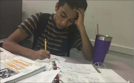  ?? CAITLIN PEBLEY PHOTO ?? Southwest High School student Luis Salas, 16, stresses over his piles of homework.
