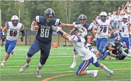  ?? MATT PARKER ?? Exeter tight end Tyler Graney fends off Winnacunne­t’s Jack Strother (1) and runs to the end zone during Saturday’s Division I game.