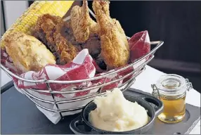  ??  ?? The basket of fried chicken with corn-on-the-cob, mashed potatoes, biscuits and gravy at Allium.