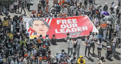  ?? The Associated Press ?? Protesters display a banner Wednesday in Yangon, Myanmar, with an image of the deposed Aung San Suu Kyi.