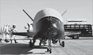  ?? Air Force via AFP/Getty Images ?? THE AIR FORCE’S X-37B Orbital Test Vehicle is inspected at Kennedy Space Center on May 7 after 718 days in orbit. The Air Force has two of the space planes, which look like small versions of the space shuttle.