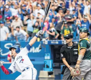  ?? CP PHOTO ?? Toronto Blue Jays’ Steve Pearce watches his walk off grand slam in front Oakland Athletics catcher Bruce Maxwell during the 10th inning of Major League action Thursday in Toronto.