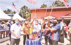  ??  ?? CINTAKAN NEGARA: Hasbi (tengah) bersama (dari kiri) Mohd Irman, Awangku Shahrizan, Sufian dan Ajes meletakkan Jalur Gemilang pada Program Merdeka@Komuniti semalam.