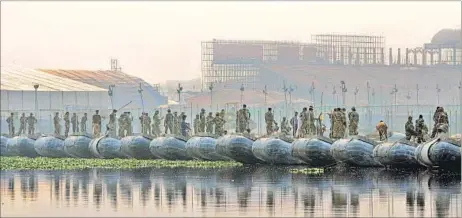  ?? SUNIL GHOSH / HT PHOTO ?? Workers assembling a pontoon bridge for visitors on the Yamuna on Thursday.