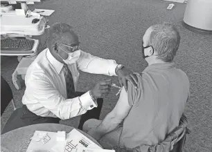  ?? PROVIDED BY DMC ?? At Detroit Medical Center’s Harper University Hospital, Eric Scott administer­s a vaccine to Michael Dobbyn, 54, of Garden City, a teacher at Hamtramck Public Schools.