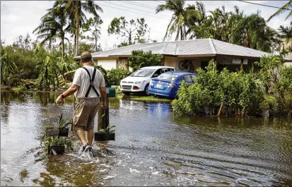  ?? EVA MARIE UZCATEGUI/BLOOMBERG ?? A resident walks home in the aftermath of Hurricane Ian in Fort Myers, Fla., in 2022. A study details how municipali­ties that rely heavily on property taxes could face huge budget shortfalls as flood-prone homes lose value or become uninhabita­ble.