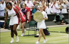  ?? TIM IRELAND — THE ASSOCIATED PRESS ?? Simona Halep walks away with her trophy after defeating Serena Williams, left, in the women’s singles final on Saturday.