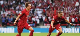  ??  ?? Mikkel Damsgaard, left, celebrates his stunning free-kick strike for Denmark