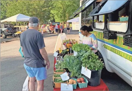  ?? ?? The Davies Farm Bus brings fresh, locally grown produce into the community at various locations on different days of the week, selling everything from onions, potatoes radishes and squash to collared greens, cabbage and peppers.