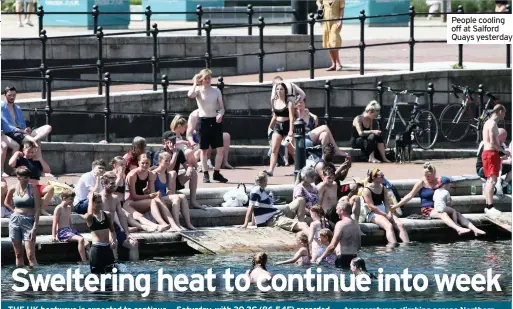  ??  ?? People cooling off at Salford Quays yesterday