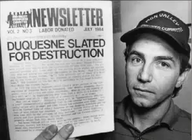  ?? John Beale/Post-Gazette ?? Barney Oursler, co-founder and co-director of the Mon Valley Unemployed Committee, holds the group’s newsletter on Aug. 28, 1984.