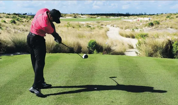  ?? DANTE CARRER/THE ASSOCIATED PRESS FILE ?? Tiger Woods tees off on the 14th hole during the Hero World Challenge in Nassau, Bahamas, last month. Woods says he is golfing without pain.