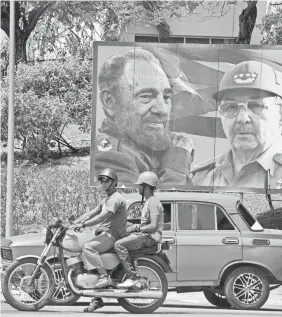  ?? RODRIGO ARANGUA/AFP/GETTY IMAGES ?? Images of Fidel Castro and Raúl Castro adorn the streets of Santiago de Cuba, southeast of Havana, in March 2012.