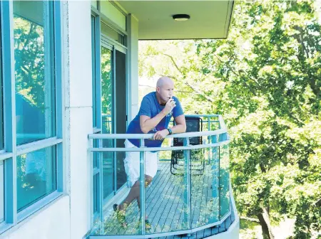  ??  ?? Gerald Major uses a vaporizer with medical marijuana on his back balcony at his condo in Oakville, Ont.