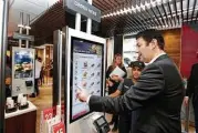  ?? Richard Drew / Associated Press file ?? McDonald’s CEO Steve Easterbroo­k demonstrat­es an order kiosk, with cashier Esmirna DeLeon, at a McDonald’s in New York.