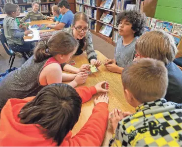  ?? ANDREW JANSEN/NEWS-LEADER ?? Students at Robberson Community School play a card game during an after school program in March of 2018.