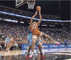  ?? AMY KONTRAS/USA TODAY ?? Texas forward Aaliyah Moore tries to get off a shot against Kansas guard Zakiyah Franklin during the second half of the Longhorns' 76-60 win in Saturday's Big 12 Tournament quarterfinals. Moore finished with 19 points and 11 rebounds.