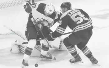  ?? MICHAELDWY­ER/AP ?? The Devils’Jesper Boqvist and the Bruins’Jeremy Lauzon battle for the puck in front of the net in the first period Sunday in Boston.