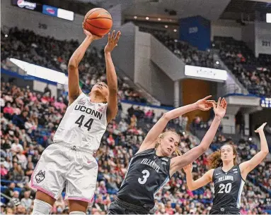  ?? Jessica Hill / Associated Press ?? UConn’s Aubrey Griffin (44) goes up for a basket while fouled by Villanova’s Lucy Olsen (3) in the second half on Sunday.