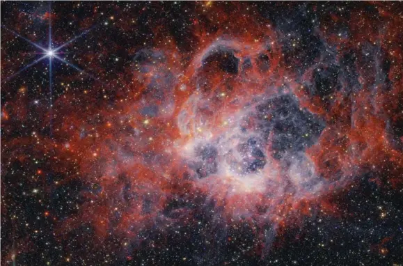  ?? ?? A near-infrared image of the star-forming region NGC 604, made using the James Webb Space Telescope. The colours are artificial so that we can “visualise” radiation not visible to the eye; different colours represent polycyclic aromatic hydrocarbo­ns, molecular hydrogen, and ionised hydrogen. Picture: NASA, ESA, CSA, STScI