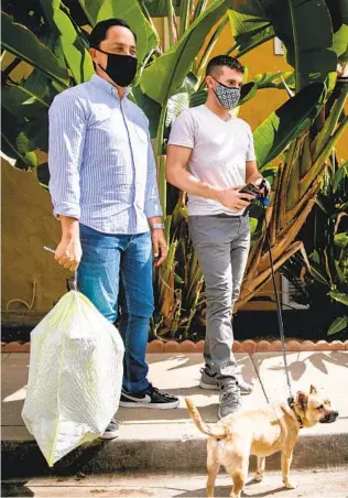  ?? SAM HODGSON U-T PHOTOS ?? Todd Gloria, the mayor-elect of San Diego, runs some “regular guy” errands Thursday as he takes out the trash before he and partner Adam Smith take their dog, Diego, for a walk.