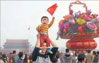  ?? ZOU HONG / CHINA DAILY ?? A young, enthusiast­ic visitor joins the crowd on National Day in Tian'anmen Square in Beijing on Sunday.