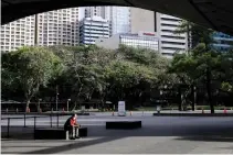  ?? REUTERS ?? A MAN wearing a protective mask sits outside a building in Makati City as the government implements an “enhanced community quarantine” in Luzon to contain the coronaviru­s pandemic.