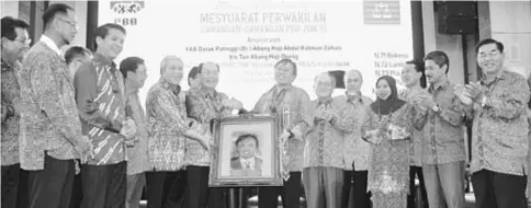  ??  ?? Gerawat (fifth left) presents a token of appreciati­on to Abang Johari (seventh right), while PBB members and leaders look on.