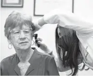  ?? JOE RAEDLE /GETTY ?? A woman gets her ear examined by a hearing specialist in
Fort Lauderdale, Florida, in 2021. In Baltimore, the city health department has created a program to expand access to hearing care for older adults.