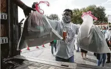  ?? Jon Shapley / Staff photograph­er ?? Johnie Jones loads donated items into a truck Monday at MacGregor Park as part of the city’s virtual parade.